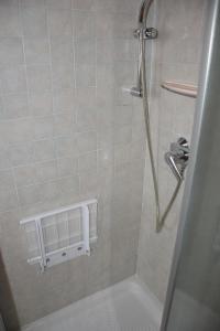uma casa de banho com um chuveiro e uma parede de azulejos brancos. em Casa di Karim em Pescantina