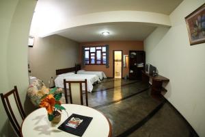 a hotel room with two beds and a table and a room with two beds at Ana Maria Apart Hotel in Arcos