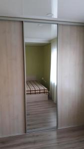 a sliding glass door with a reflection of a bedroom at Apartment on the World in Cherkasy