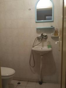 Un baño con lavabo, espejo e inodoro. en Аria B&B, en Burgas 20 fotos más