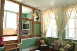 a living room with green walls and a mirror at Gästehaus Tobringen 20 in Tobringen