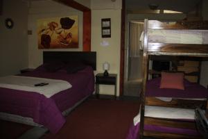 1 Schlafzimmer mit 2 Etagenbetten mit lila Bettwäsche in der Unterkunft Hostal Los Guindos in Temuco