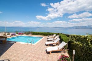 a swimming pool with lounge chairs and the ocean at Apartments Grlica in Sutivan