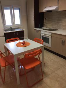 カリテア・ハルキディキにあるCenter Kallithea Apartmentのキッチン(白いテーブル、オレンジの椅子付)