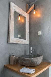 a bathroom with a stone sink and a mirror at Aretousa Deluxe Downtown Apartment in Skala