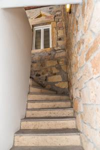 a staircase with a stone wall and a window at Aretousa Deluxe Downtown Apartment in Skala