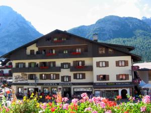 ein Gebäude mit einem Blumenstrauß davor in der Unterkunft Hotel Posta in Sappada + 27 Fotos