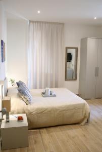 una camera con un grande letto e uno specchio di Real Rooms a La Spezia