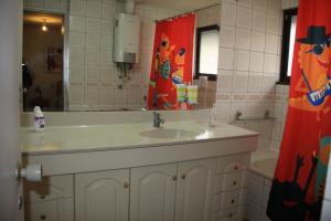 ein Badezimmer mit Waschbecken, Spiegel und Badewanne in der Unterkunft Hostal Los Guindos in Temuco