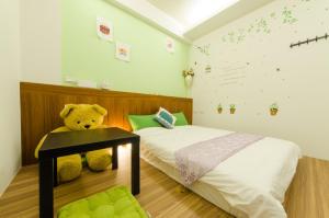 a teddy bear sitting on a table in a bedroom at Smile Castle in Luodong