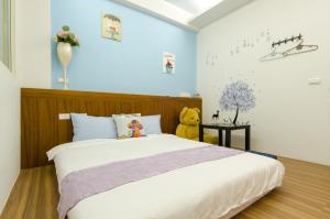 a bedroom with a bed with a teddy bear on it at Smile Castle in Luodong