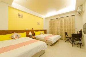 a hotel room with two beds and a desk at Smile Castle in Luodong