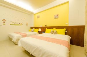 two beds in a room with two teddy bears on them at Smile Castle in Luodong