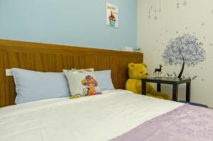 a bedroom with a bed with a teddy bear on it at Smile Castle in Luodong