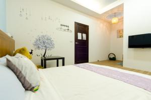 a bedroom with a bed with a teddy bear on it at Smile Castle in Luodong