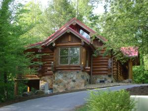 a log cabin in the woods with a driveway at Bearly Lovers in Gatlinburg