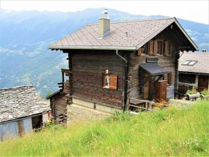 an old house on a hill with mountains in the background at Chalet "Chez Claudine et Charles" in Mase