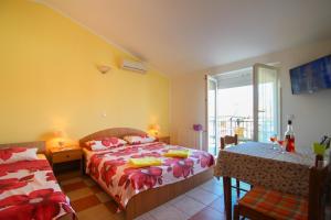 ノヴィグラード・イストラにあるApartments Mianiのベッドルーム1室(ベッド2台、テーブル、窓付)