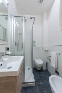 a bathroom with a shower and a sink and a toilet at Hotel Suisse in Marina di Pietrasanta