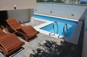 a pair of chairs and a swimming pool at Villa Sunshine in Trogir