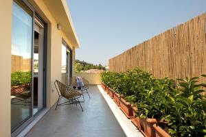 a balcony with chairs and potted plants and a fence at Acropolis View Luxury Apartment in Athens