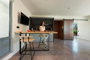 a woman sitting at a table in a kitchen at Acropolis View Luxury Apartment in Athens