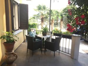 a table and chairs on a balcony with plants at Rooms Tusculum in Opatija