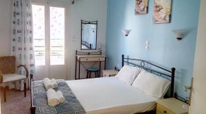 斯卡拉Galini Hotel Bed and Breakfast的一间带床、镜子和窗户的卧室