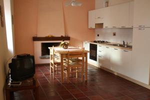 eine Küche mit einem Tisch und einem TV in der Unterkunft Cà Veja in Montà