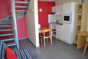 una pequeña cocina con una mesa de madera y una escalera en Appart'hotel City Mons Centre en Mons