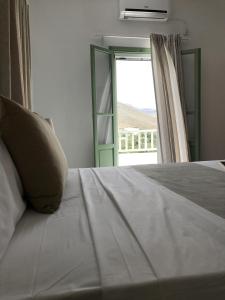 a bedroom with a bed with a large window at Panai's Garden in Livadi Astypalaias