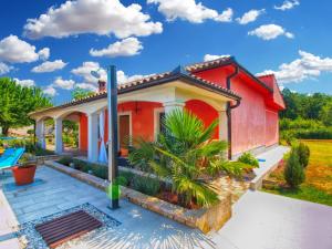 czerwony dom z palmą przed nim w obiekcie Holiday Home Villa Angelina 1233 w mieście Barban