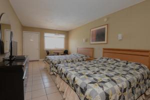 a hotel room with two beds and a television at Sea Garden Motel in Seaside Heights