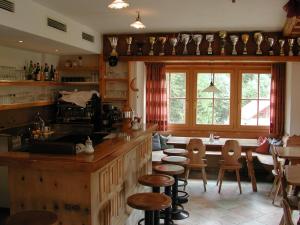 - une cuisine avec un comptoir, des chaises et une table dans l'établissement Hotel Gomagoierhof, à Stelvio