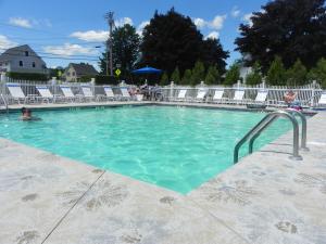 ein Pool mit Stühlen und eine Person im Wasser in der Unterkunft Elmwood Resort Hotel in Wells