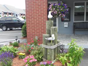 a garden with flowers and a bird statue in front of a building at Elmwood Resort Hotel in Wells