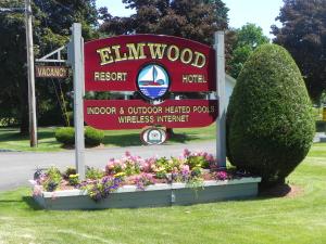 a sign for the elijah wood resort with flowers at Elmwood Resort Hotel in Wells