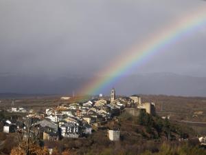 a city with a rainbow in the sky at Hostal Carmen in El Puente