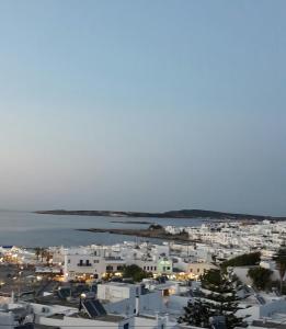 a view of a town with white buildings and the ocean at Katerina Apartments & Studios in Naousa