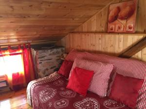 1 dormitorio con 1 cama con almohadas rojas y blancas en La Maison des Fées, en Mex