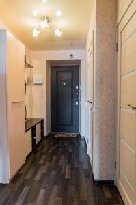 キーロフにあるApartamenty na Surikova 50の黒いドアと木製の床の廊下