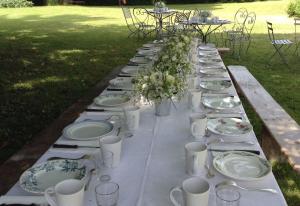 - une grande table avec des assiettes et des ustensiles dans l'établissement Saint Victor La Grand' Maison, à Ingrandes