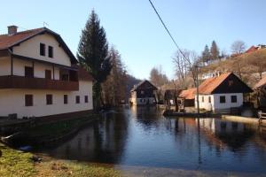 a group of houses and a river with buildings at Rooms Roza in Slunj