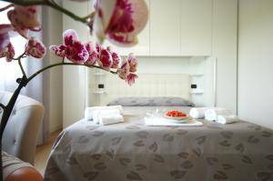 a bed with a table with a plate of food on it at Hotel Ristorante Fortuna in Cavallino-Treporti