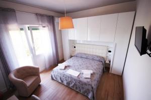 a small bedroom with a bed and a chair at Hotel Ristorante Fortuna in Cavallino-Treporti