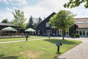 un parc en face d'une maison avec un arbre dans l'établissement Hotel De Kruishoeve 's-Hertogenbosch - Vught, à Vught