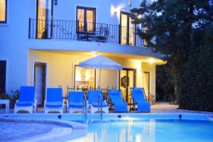 a group of blue chairs and an umbrella next to a pool at Villa Lycia in Kalkan