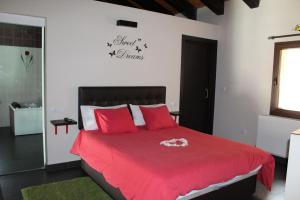 a bedroom with a red bed with red pillows at Loboratorio Rural-Cuenta hasta 3 in Umbrías