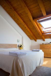 a bedroom with a large white bed with a skylight at Appartamento A Due Passi in Farra dʼAlpago