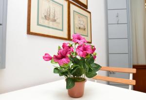 un jarrón con flores rosas sentado en una mesa en Sissi Suite, en Venecia
